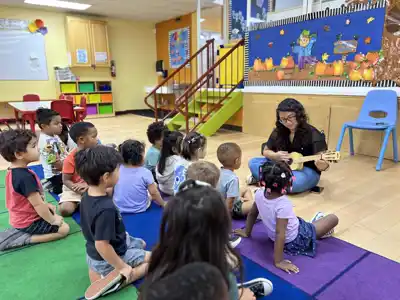 Children learning music fundamentals and rhythm during an interactive music enrichment lesson at Sierra Preschool