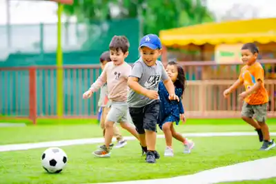 Preschool children learning teamwork and athletic skills during an organized soccer enrichment activity at Sierra Preschool